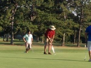 Ott Chandler watches his putt roll toward the cup on the 16th green Saturday at Pine Hill CC.