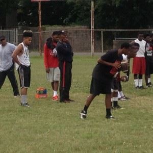 Anniston High football coach Eddie Bullock (C) knows the importance of getting things done in the summer.