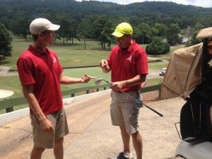 Haden (L) and Michael Downey inspect the sand wedge Michael used to hole out for birdie on 18 at ACC Friday in the Sunny King.