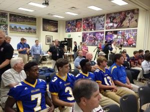 Piedmont captains (from left) Dreek Thompson, Cody Daughtry, C.J. Savage and Tyler Lusk and coach Steve Smith listen to opening remarks about the Champions Challenge. Below, Smith watches his charges in action during the 7-on-7 camp his team won.