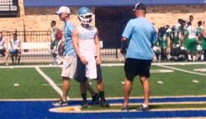 Pleasant Valley coach Jeff Davis (R) reviews a play with quarterback Drew Lewiski during the Piedmont 7-on-7 camp this summer. In the main photo, the Raiders approach the line of scrimmage to run a play.