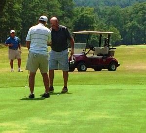 David Sanders (L) is congratulated by Ott Chandler after winning the Calhoun County Senior Championship in a playoff Saturday. Below, Sanders and Cane Creek director of golf Kenny Szuch check out the scoreboard.
