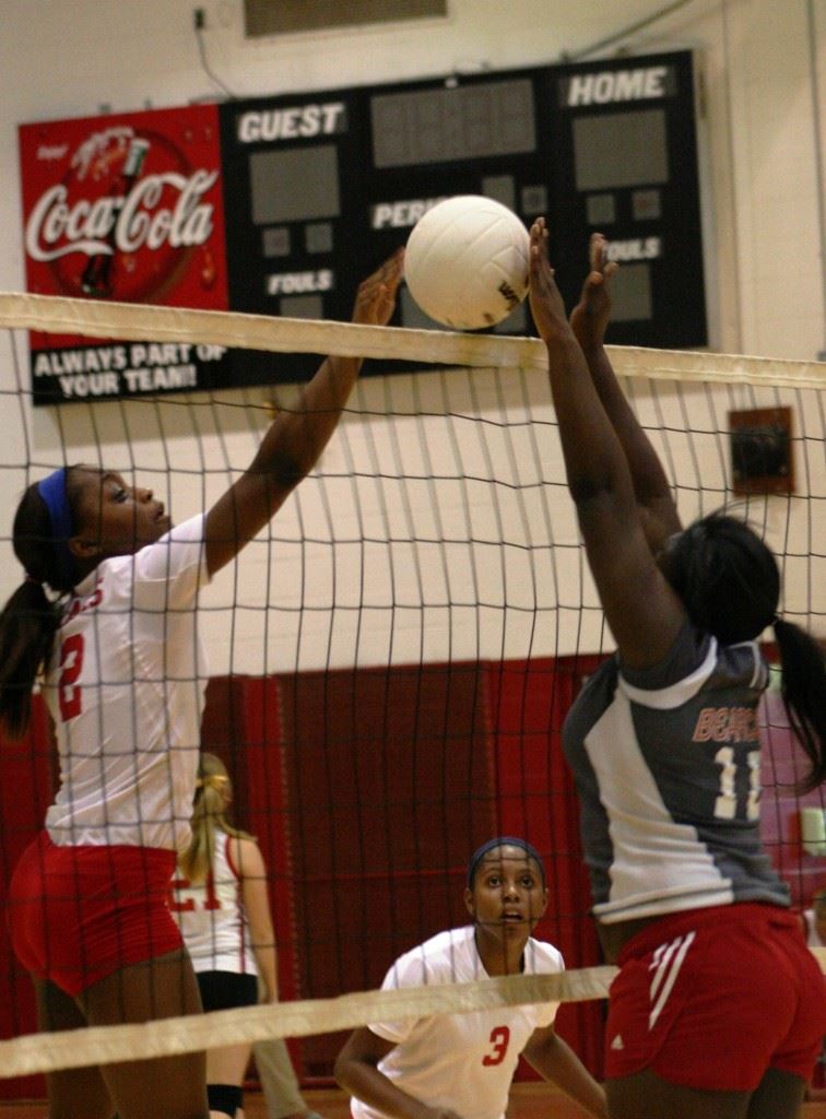Saks' Maiya Northard (2) is blocked at the net by Weaver's Jazmyn Mosely during Thursday's match. In the cover photo, Saks coach Randy Law brings his team together before the match. (Contributed photos)