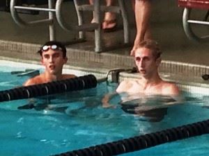 Trace Hilbun (L) and Colton Smith cool down and watch the other swimmers finish after their race in the YMCA Blue Dolphins' Spectacular September Splash on Saturday.