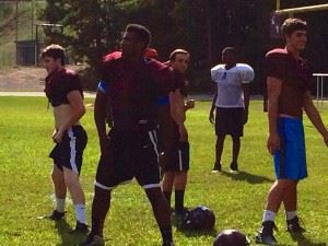 Parker Morgan (L), Justin Foster (C) and Axis Heathcock lead their Donoho teammates in pre-practice stretching. All three are among the leading tacklers on the stingiest defense in Calhoun County.