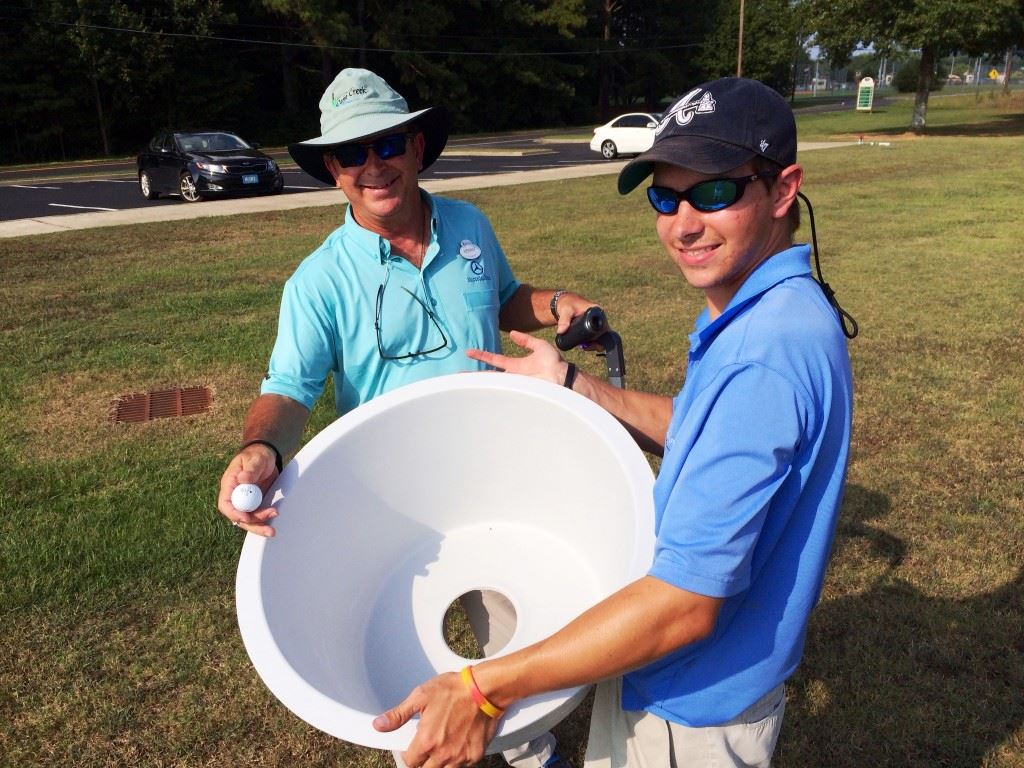 Anniston city golf director Kenny Szuch (L) and Jackson Johnson display the containers that will serve as holes for the introductory FootGolf course being set up adjacent to the soccer complex at McClellan. 