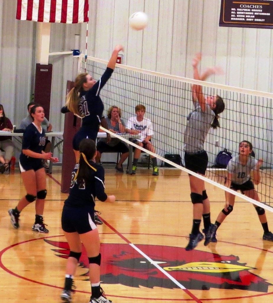 Sacred Heart's Olivia Simmons (21) goes high to get one of her five blocks in the Cardinals' sweep Thursday.