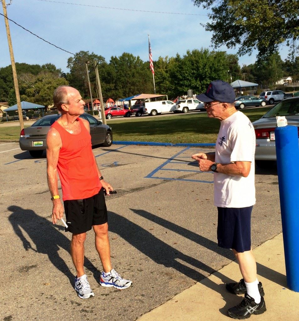 Fred Campbell (R) and Charlie Browning go over the race after finishing 1-2 overall in the Masters Games 5K. In the bottom photo, Connie Edwards of Alpine, the first woman across the line, collects her medal from Dennis Dunn of the Anniston Lions.