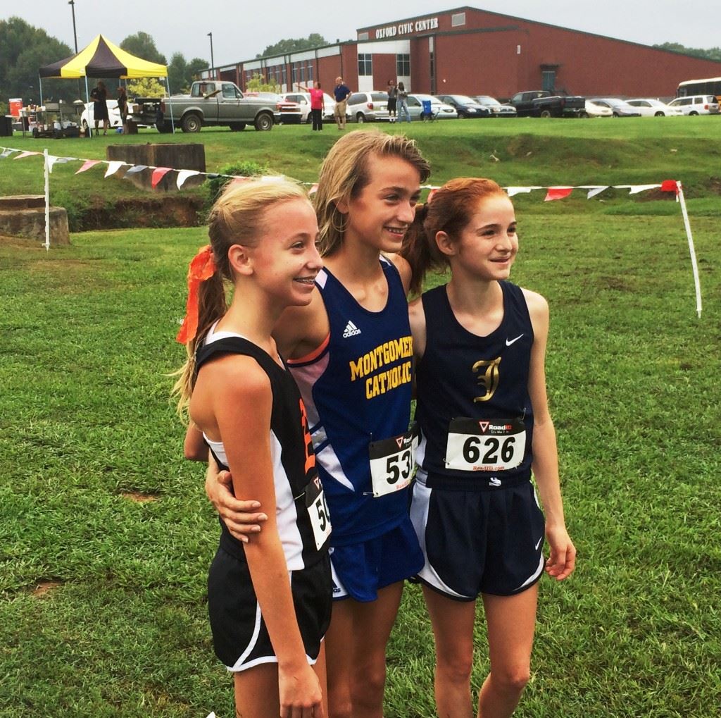 Alexandria's Abby Nunnelly (L) and Jacksonville's Rebecca Hearn (R) flank Catholic-Montgomery's Amaris Tyynismaa after running earlier this year at Oxford Lake. All three are expected to finish high in their respective state championship races Saturday in Moulton. Hearn and Tyynismaa are in the same race (4A). 