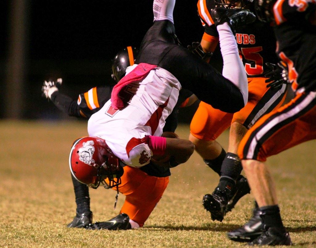 Alexandria running back Alton Davis (top) gets turned on his head by Anniston's defense, while Anniston quarterback Quint Dobbins (4) gets the same treatment by Alexandria's defense as Davis. (Photo by Greg McWilliams)