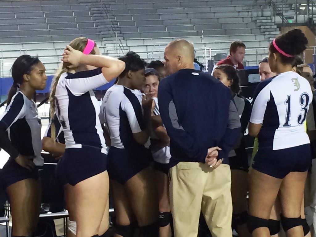 Jacksonville coach David Clark consoles his team after it fell to Danville in the Class 4A state volleyball final Thursday. On the cover, the Golden Eagles watch the Hawks celebrate their first state championship.