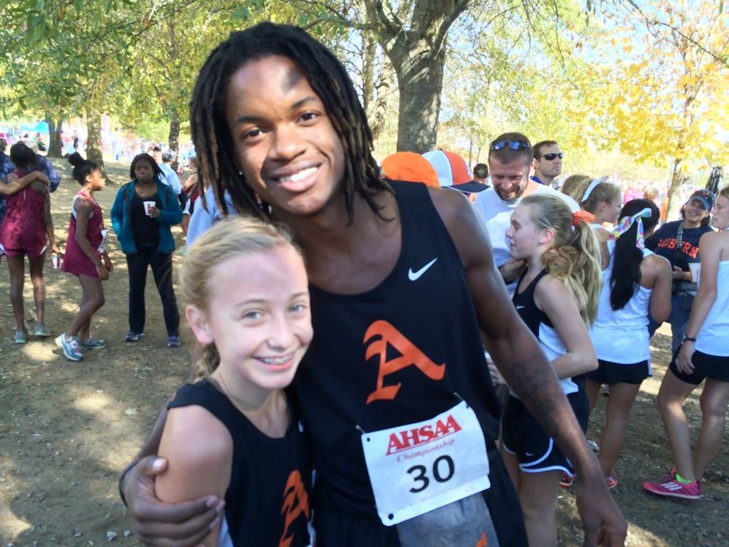 Alexandria's Ronnie Royal (30) congratulates Abby Nunnelly on her second-place finish in the Class 5A girls race. On the cover, Rachel Faucett hits the tape as Pleasant Valley's first runner.