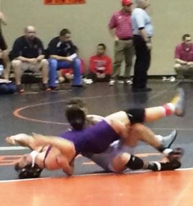 Oxford's Speed Pitts (white), wearing a mask to protect a broken nose, puts Madison County's Austin Foote in a tough spot during their 145-pound final Monday. 