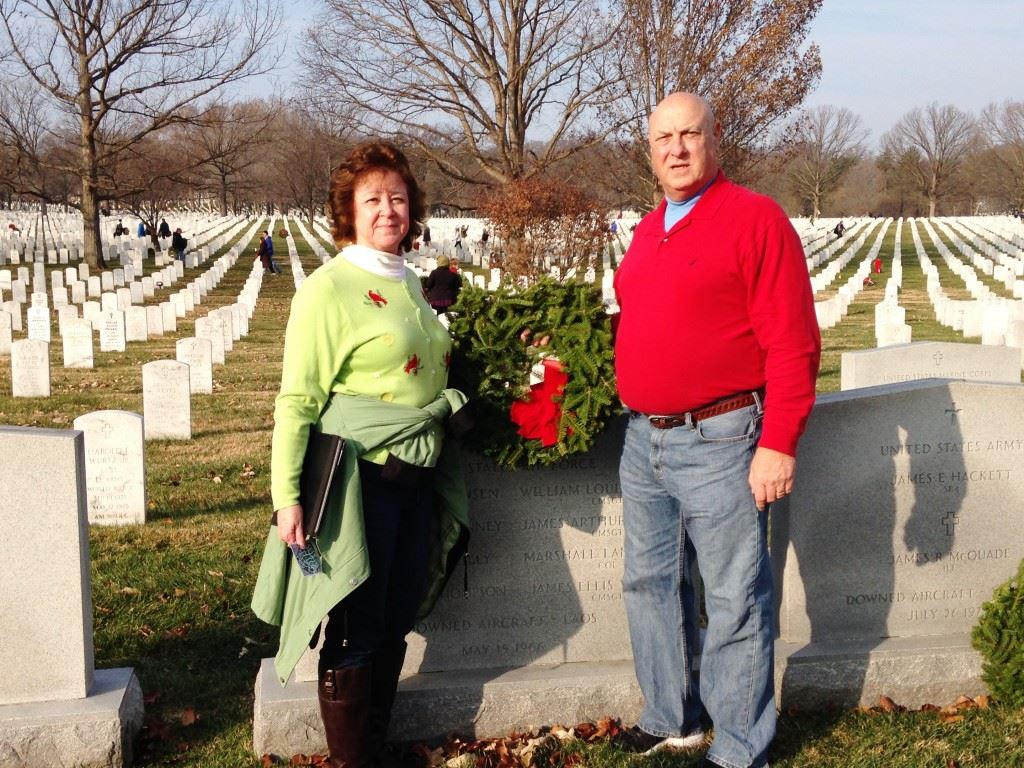 Pleasant Valley football coach Jeff Davis and his wife Dotty prepare to lay a wreath at the grave of the uncle of one of his assistant coaches interred at Arlington National Cemetery. On the cover, Davis kneels beside the headstone marking the grave of James Arthur Preston, the uncle of Raiders assistant coach Ronnie Preston. Below, children pause after laying a wreath at a gravesite. (Photos courtesy of Jeff Davis) 