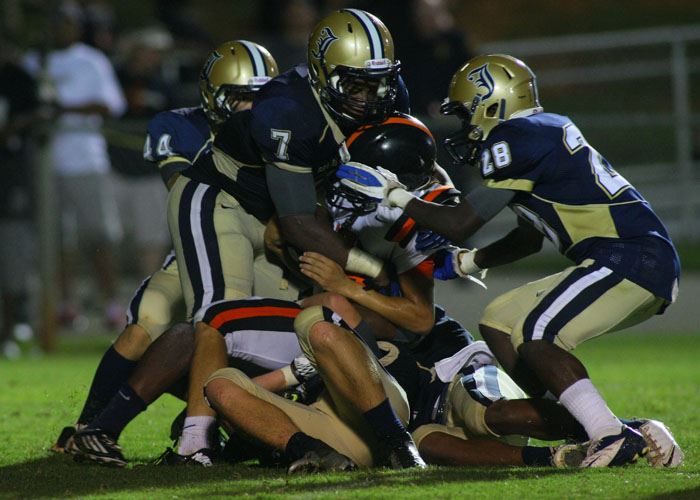 Jacksonville linebacker Savon Parker (7) wraps up an Alexandria ballcarrier. On the cover, Sid Thurmond (9) sizes up a Saks runner. (Photos by Greg McWilliams) 