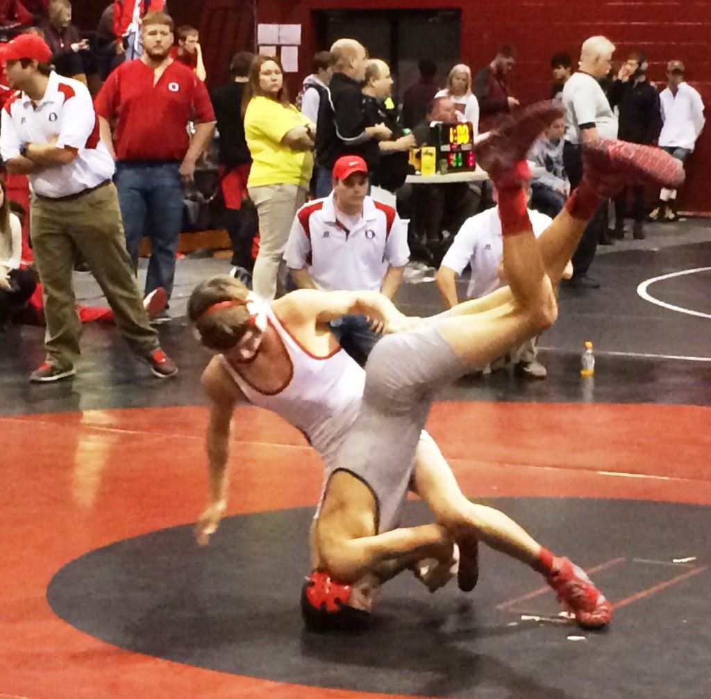 Ohatchee's Jimmy Wilson (white) gets Weaver's Nick Souder in a bad position during their 106-pound title bout in Heflin Saturday, but Souder bounced back to pin his opponent. On the cover, Cleburne County's Tyler Mayfield displays his 152 champions medal and the trophy for being named outstanding wrestler of the Rumble in the Jungle.