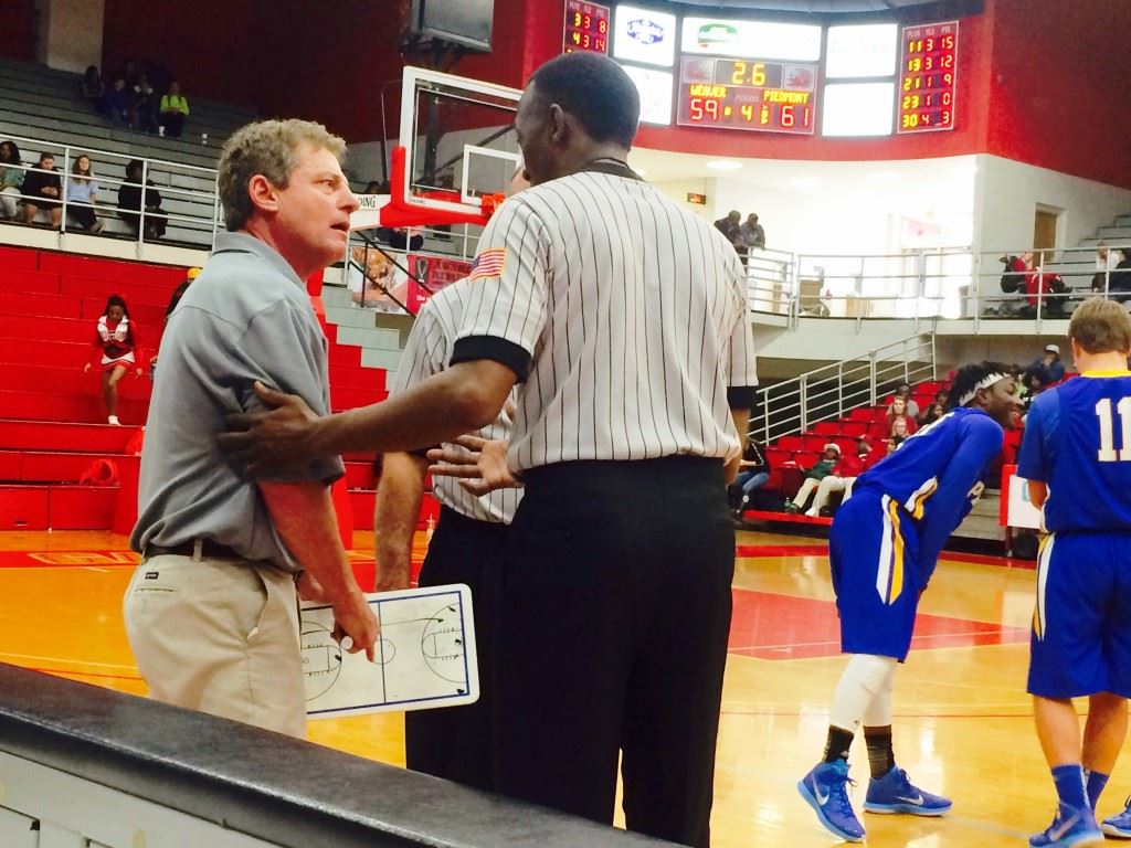 Piedmont coach Tommy Lewis (L) seeks an explanation from official Earl Warren for the additional second placed on the clock at the end of their game with Weaver.