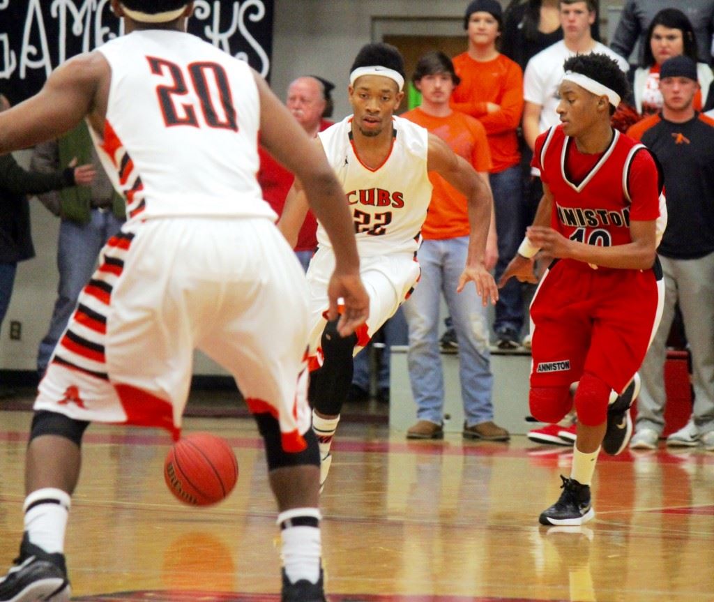 Alexandria's Tyrelle Gay (22) brings the ball upcourt with Anniston's Tray Croft in pursuit. On the cover, Alton Davis (20) and Luke Tucker (30) react to a big play in the Valley Cubs' victory. (Photos by Chad Barnett)