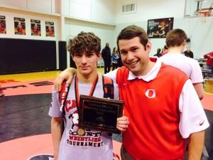 Ohatchee's Payton Entrekin (L), with coach Matt Sweatman, was voted most valuable wrestler of the tournament. On the cover, Oxford coaches Matt Tanner (L) and Brandon Jerome intently watch their wrestlers.