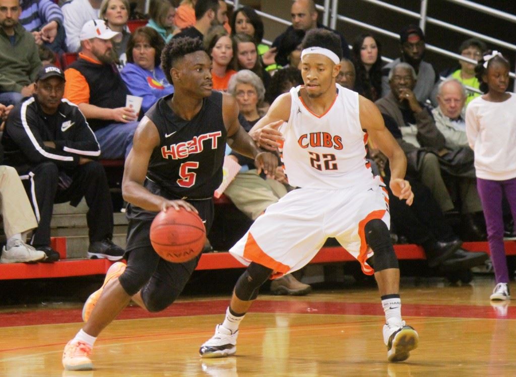 Sacred Heart's D.J. Heath (5) was named MVP of the Calhoun County Boys Tournament. He's being challenged here by Alexandria's Tyrelle Gay during Saturday's championship game. (Photo by Chad Barnett)