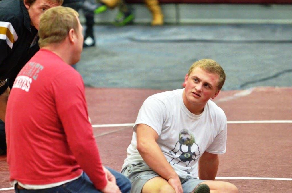 'Secret sloth' creator Hunter Lee stretches in the sloth T-shirt popular with Oxford wrestlers and their fans this season. On the cover, freshman Carson Lindsay carries his sloth away at the 6A South Super Sectional. (Photos by Selina Lee)