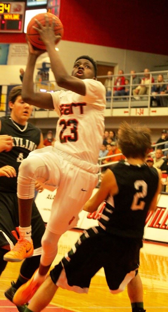 Kevion Nolan (23) drives between Skyline's James Guest (2) and Noah Tidwell for Sacred Heart's first basket of the game. (Photo by Shannon Fagan). On the cover, Diante Wood played a big role in the Cardinals' victory. (Photo by Al Muskewitz)