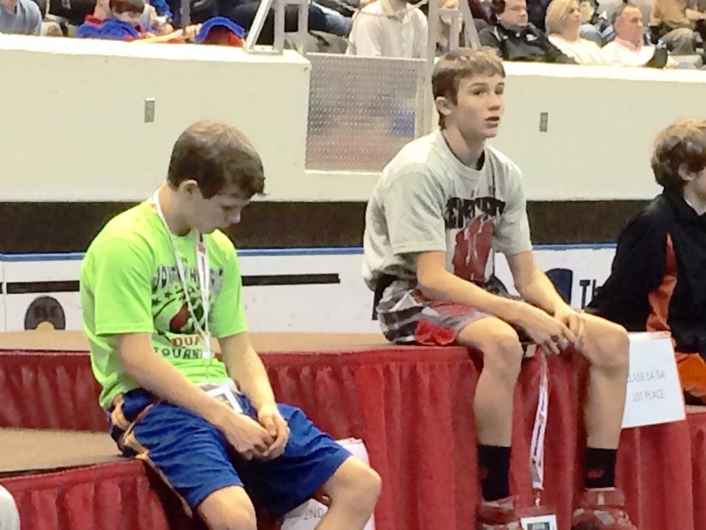 Weaver's Nick Souder (R) and Ohatchee's Jimmy Wilson await the awards ceremony after their 1A-5A 106 title bout. On the cover, Souder and Wilson lock up early in their match.