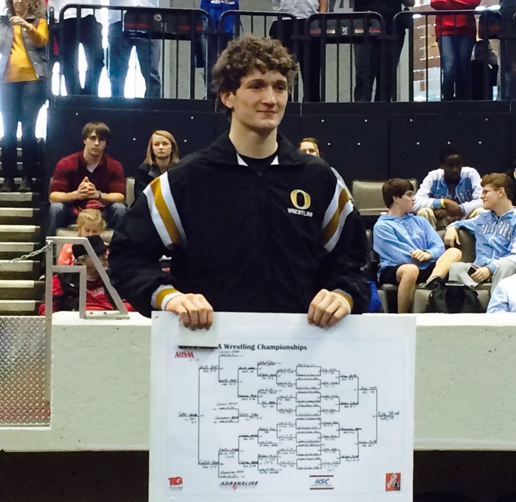 Oxford's Matt King stands on the podium with a copy of the 6A 138-pound weight class he dominating to win the state championship.