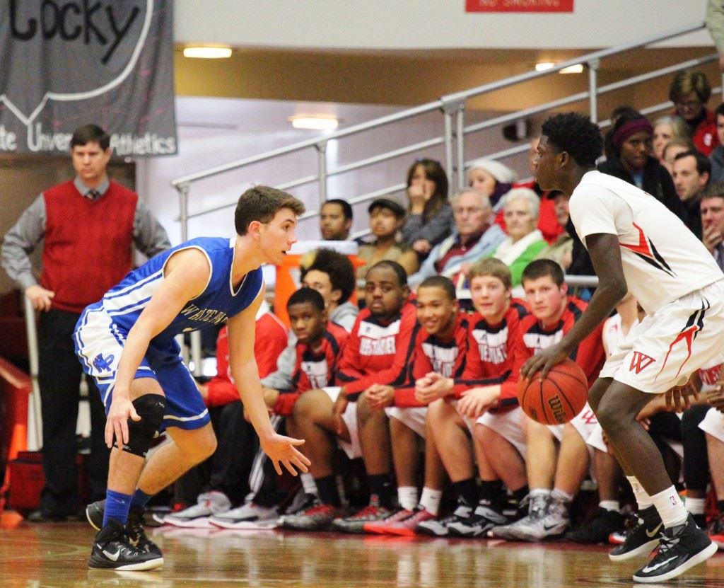 White Plains' Eli Hightower (L) takes his defensive stance against Westminster tournament MVP Trey Petty. On the cover, Wildcats coach Chris Randall embraces seniors Dillon Greenwood and Kolby Burgess (5) when it was over. (Photos by Micaela Truett)