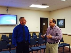 New White Plains football coach Chris White (L) talks with Calhoun County school board member Phil Murphy after being approved by the board Thursday night.