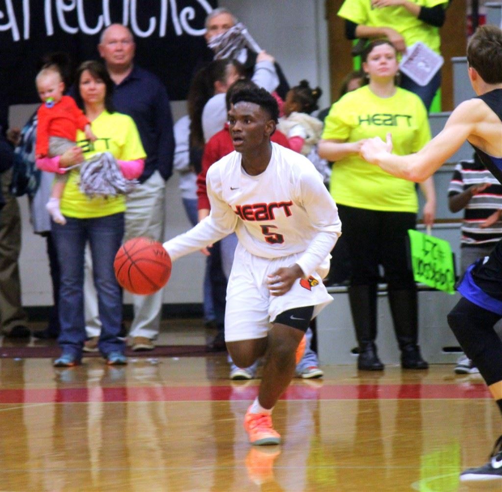 Sacred Heart's D.J. Heath brings the ball up the floor at Pete Mathews Coliseum. On the cover, Angel Kidd runs the show for Jacksonville. (File photos)