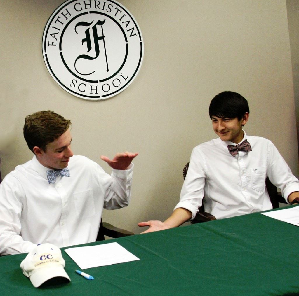 Faith Christian seniors Josiah McDaniel (L) and Tyler Johnson congratulate each other after their college signing ceremony Wednesday. (Photo by Carey Jenkins)