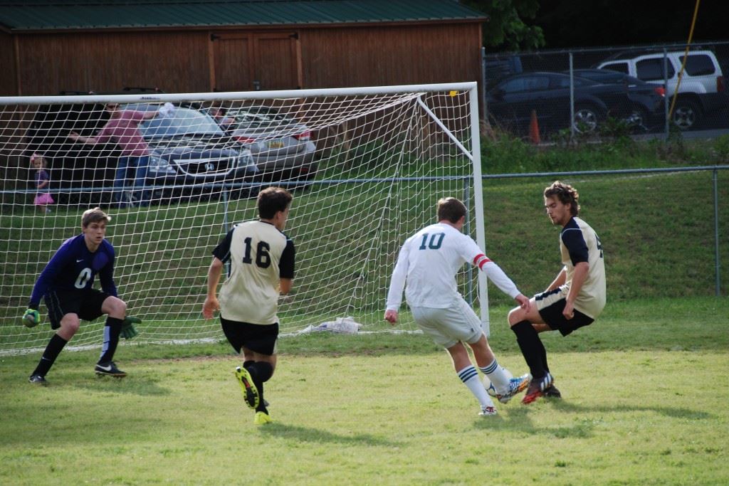 Faith Christian's Josiah McDaniel (10) splits two Altamont defenders and freezes the keeper before scoring the game's second goal. (Photo by Tony Bedford)