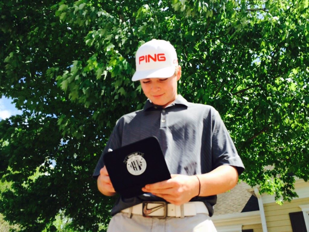 Hewitt-Trussville's Logan Archer checks his scorecard after shooting 2-under-par 70 at Cider Ridge Monday. On the cover, White Plains players Dustin Travis, Layton Bussey and Trevor Lane play together to complete their round.