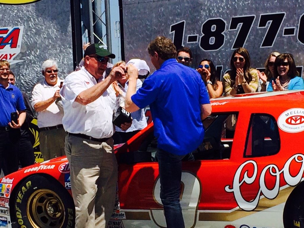 Talladega Superspeedway chairman Grant Lynch (L) greets Bill Elliott in Victory Lane after the NASCAR Hall of Famer recreated his famous 1985 comeback in a four-lap run in that same car Wednesday. On the cover, Lynch, Elliott and Eli Gold share memories of that race.