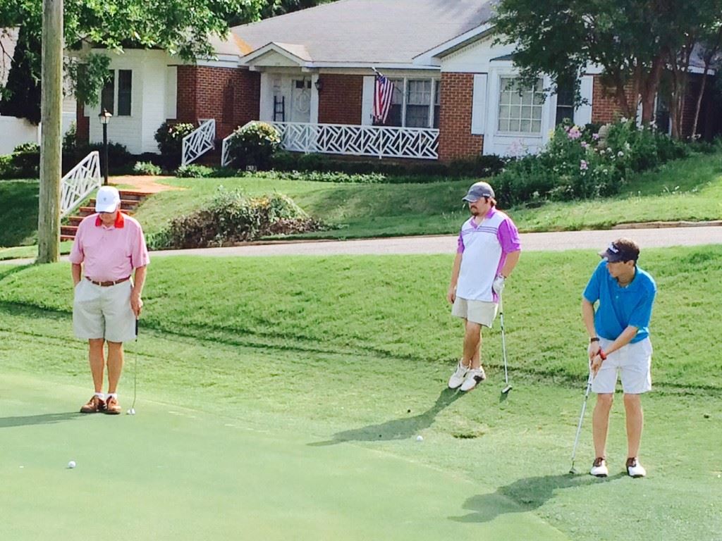 Jackson Johnson (R) rolls a putt from the fringe on the 16th green Saturday. Waiting their turn to putt are Anniston Country Club's Bob Kennamer (L) and Johnson's Cane Creek teammate Janson Wilborn.