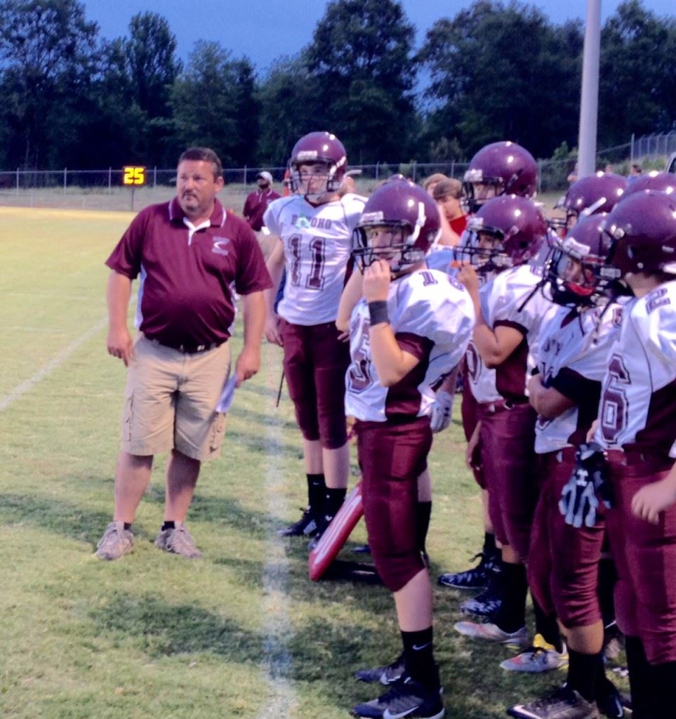 New Donoho football coach Andy McWilliams and Cotton Banks (11) watch the action unfold in Thursday's spring football game with JCA.