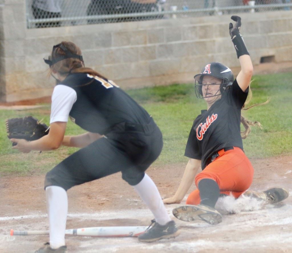 Alexandria's Timberlynn Shurbutt slides home with a second run to score when Lincoln went home on Lauren O'Dell's infield grounder in the third inning Wednesday. Lincoln pitcher Reanna Powell is awaiting a throw that was late in arriving. (Photo by Kristen Stringer/Krisp Pics Photography)