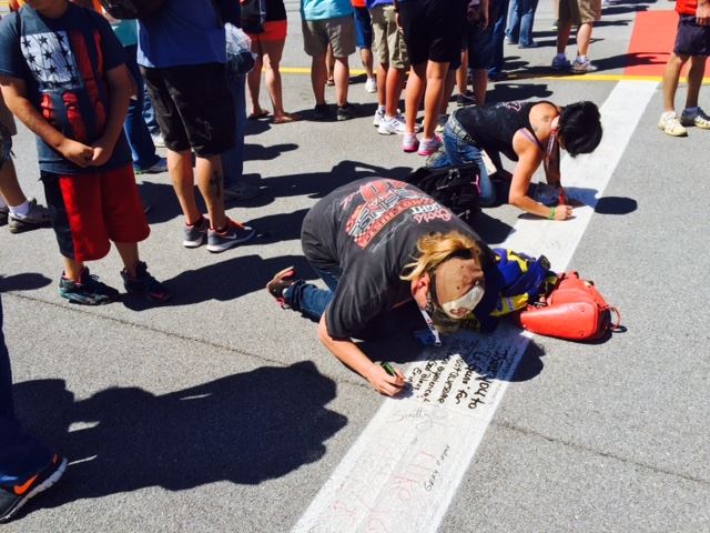 Erin Williams of Corpus Christi, Texas, leaves a personal message on the start-finish line during her first visit to Alabama and Talladega Superspeedway. (Photo by Al Muskewitz)
