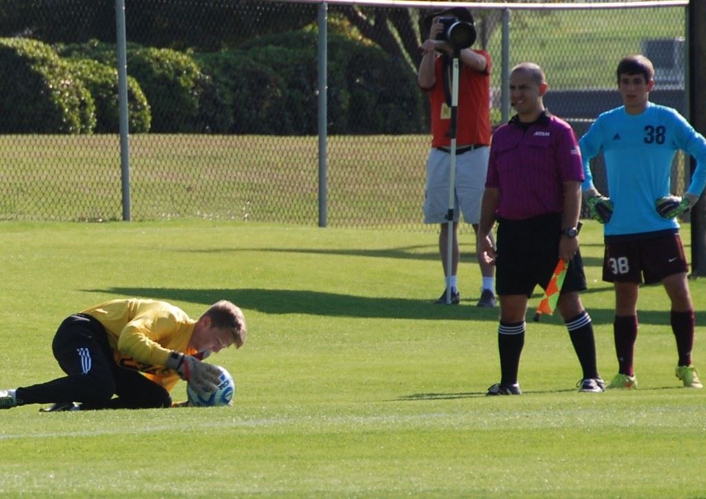 Faith keeper Caleb McCord smothers Madison Academy's final penalty kick to preserve the Lions' victory. On the cover McCord makes his move on the shot. (All photos by Tony Bedford)