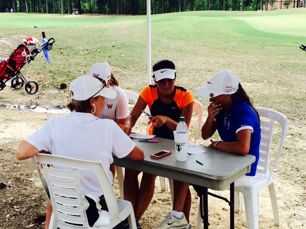 White Plains' Layne Dyar (R) and Jordan Gregoria (C) review their scorecards after their round Monday.