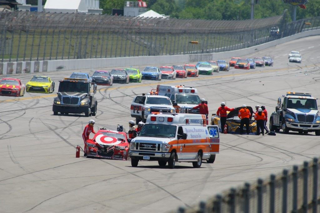 Emergency crews attend to crumpled cars while the race is red-flagged on Lap 47. On the cover, cars scatter during the biggest incident of the race.