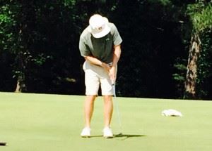 Former Auburn All-American Glenn Northcutt drops a birdie putt on the fourth green Friday. On the cover, Kyle Sapp checks the pin position on No. 6 after just making an eagle on 5 in the opening round of the Fort McClellan Credit Union Pro Invitational.