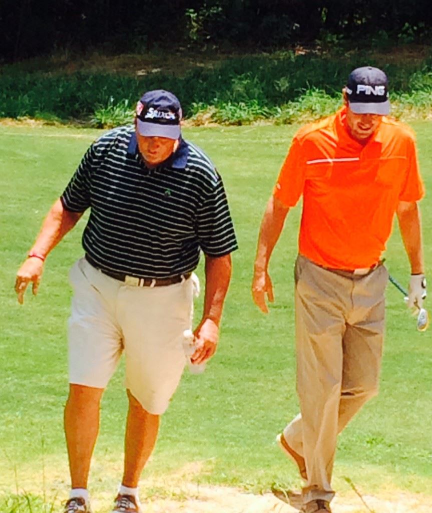 Rob Willbanks (R) gets some course tips from pro-am teammate Ron McClellan as they leave the 14th tee at Cider Ridge GC Monday.