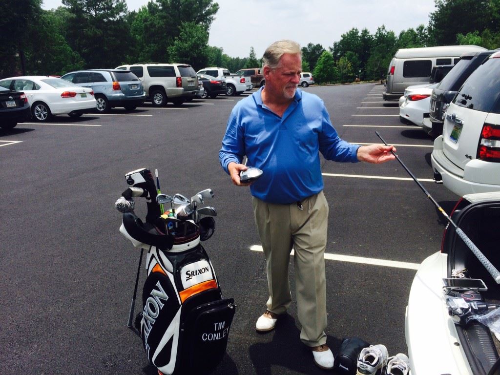 Tim Conley adjusts his equipment after shooting 68 Tuesday to grab a share of the Oxford Senior Open lead. On the cover, co-leader Danny Edwards tees off under overcast skies. 