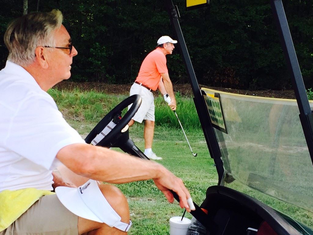 Bob Kennamer (foreground) focuses on the result of partner John Carrozza's approach shot from the rough on the final hole of their match.  