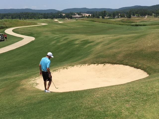 Brennan Clay steps into the bunker below the right side of the green on Heartbreaker No. 1. Both nines in the Sunny King round at Silver Lakes start with par-5s. (Photo by Al Muskewitz)