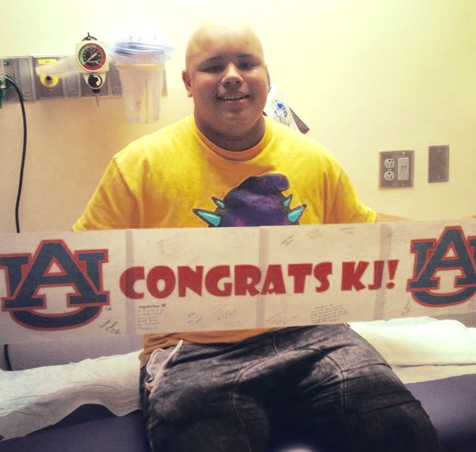 Oxford sophomore lineman K.J. Lynch unfurls the banner he received from the doctors and nurses at Children's Hospital in December after his final chemo treatment to knock out his cancer. On the cover, he talks about the ordeal wearing the undershirt that expresses his post-treatment attitude.