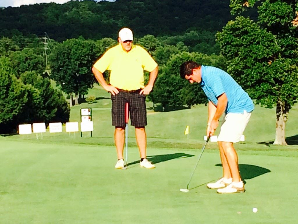 Dalton Chandler (R), under the watchful eye of his father Ott, sinks a 15-foot birdie putt on 18 that clinched the Buddy Moore Charity Classic.