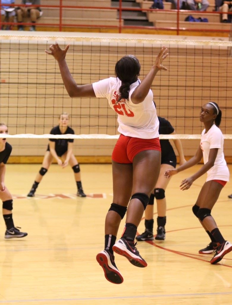 Saks' Jordan Briskey winds up for a big slam during Tuesday's area match with White Plains. Below, White Plains' Ann-Katherine Dothard (12) and Hannah Barno combine for a block at the net. (Photos by Kristen Stringer/Krisp Pics Photography)